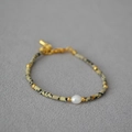Dettaglio della collana con perle di pietra maculata e una perla d'acqua dolce bianca centrale - Bracciale
