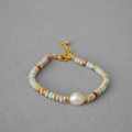 Detail of beaded necklace with blue natural stones and large white baroque pearl accent - Bracelet