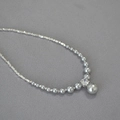 Dettaglio di perle grigie sfumate e grani d'argento con pietra di zircone centrale brillante - Finta Perla Grigio Argento