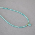 Macro shot of turquoise beaded necklace with a teardrop stone pendant and gold accent beads - Amazonite