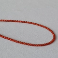 Dettaglio macro di eleganti perle di agata rossa traslucida con finitura lucida - 3-3.5mm