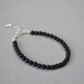 Close-up of minimalist black onyx beaded bracelet with adjustable silver lobster clasp - 4mm / Black Agate