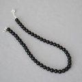 Detail of elegant black onyx beaded necklace with silver lobster clasp and extension chain - 8mm
