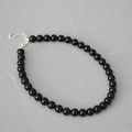 Dettaglio collana con perline di onice nero con chiusura a moschettone e catena d'estensione - 10mm