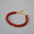 Close-up of deep red agate beaded bracelet with gold extension chain on gray background - 6mm / Red Agate