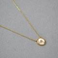 Elegante collana in ottone dorato con pendente tondo in madreperla e pietra centrale lucida - Madreperla Bianca
