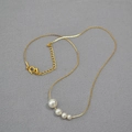 Minimalist gold brass necklace featuring a gradient of four elegant white pearls - Gold