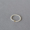 Detalle macro de cuenta de oro de 14K y perlas translúcidas en el anillo fino - US 6 / 2mm