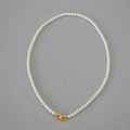 Detailed shot of white round pearls with a golden infinity-shaped metal clasp - Creamy White Necklace 4mm