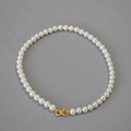 Close-up of elegant white pearl necklace featuring a golden infinity symbol clasp - Creamy White Necklace 8mm
