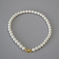 Detail of high-gloss round pearl necklace with elegant gold S-shaped metal clasp closure - Creamy White Necklace 10mm