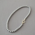 Elegant grey round pearl necklace with a gold micro-pave zircon buckle on felt background - 8mm Silver Gray