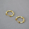Detailansicht goldbeschichteter Creolen mit cremefarbener Emaille und Klappverschluss - Cremeweiß