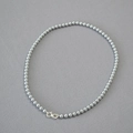 Detailed close-up of grey pearl necklace featuring a silver infinity clasp on fabric - Silver Gray Necklace 5mm