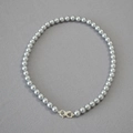 Detailed close-up of grey pearl necklace featuring a silver infinity clasp over textured fabric - Silver Gray Necklace 8mm