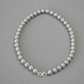 Detail of grey pearl necklace with silver infinity clasp on textured fabric - Silver Gray Necklace 10mm