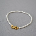 Detail of high-gloss round pearl necklace with gold lobster clasp on grey background - Creamy White Bracelet 3mm