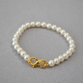 Detail of elegant white pearls necklace with a polished gold infinity figure-eight clasp - Creamy White Bracelet 6mm