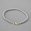 Detail of grey pearl bracelet featuring a silver infinity clasp on textured fabric - Silver Gray Bracelet 4mm