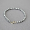 Detail of gray imitation pearls and gold infinity clasp on an elegant beaded bracelet - Silver Gray Bracelet 5mm