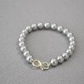 Detail of grey imitation pearl necklace featuring a silver infinity clasp on textured fabric - Silver Gray Bracelet 8mm