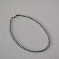 Dettaglio di collana con perle grigio scuro e chiusura magnetica in argento lucido - 4mm / Grigio