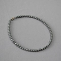 Primo piano di collana di perle grigio scuro con chiusura a cuore in argento - 6mm / Grigio
