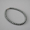 Deep grey Tahitian style pearl necklace with metallic clasp on textured surface - 10mm / Gray