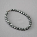 Close-up of high-luster dark grey pearl necklace with metallic silver lobster clasp detail - 12mm / Gray