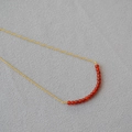 Minimalist gold necklace with a curved row of red agate beads and a delicate chain - Red Agate