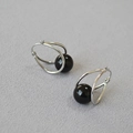 Detailed close-up of silver-tone double-hoop earrings featuring black agate spheres - Platinum + Black Agate