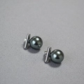 Gros plan sur les boucles d'oreilles en argent 925 avec perles noires et barre en T minimaliste - Gris Tahiti 12mm
