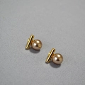 Détail de boucles d'oreilles barre dorée avec perles lisses sur un fond gris neutre - Café 10mm