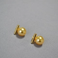 Vue macro de boucles d'oreilles en perles dorées avec barre lisse sur tissu gris - Or 12mm