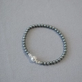 Macro detail of Tahitian faux pearl necklace with silver magnetic clasp on grey fabric - 4mm Bracelet / Tahiti Gray
