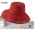 Detail of orange cotton bucket hat featuring Seek your beauty golden embroidery - One Size 58cm / Orange