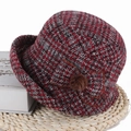 Détail d'un chapeau cloche en tweed rouge à carreaux avec nœud et pompon en fourrure - Bordeaux