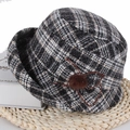 Close-up of elegant plaid winter bucket hat with floral detail on a woven mat background - Black & White