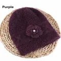 Plush purple cable-knit beanie featuring a crochet flower and pearl on a straw mat - Elastic 56-59cm / Purple