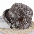 Detailed texture of brown plaid winter bucket hat with bow and pompom decoration - Brown
