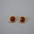 Close-up of gold-plated sunburst stud earrings with red and black enamel inlay details - Red Enamel Black Agate