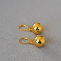 Macro view of French style minimalist hollow gold plated ball earrings on gray fabric - 14mm / Gold