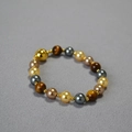Collana retrò con perle occhio di tigre e chiusura magnetica dorata su sfondo grigio - Bracciale