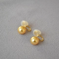 Détails macro de boucles d'oreilles clips perles dorées avec attaches en U et coussinets - Or 10mm