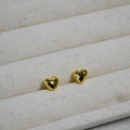 Dettaglio macro di orecchini a cuore in oro lucido su un vassoio espositivo in crema - Orecchino a cuore singolo