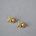 Detailed shot of X-shaped gold earrings with zircon stones and champagne pearls - Coffee (10mm)