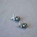 Close-up of X-shaped silver earrings with sparkling cubic zirconia and dark grey pearls - Tahitian Black (10mm)