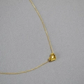 Poliertes Gold Hammered Herz Anhänger Halskette mit feiner Kette auf Stoffhintergrund - Gold