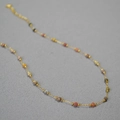 Collana minimalista in oro con perle in pietra sfaccettate colorate su sfondo grigio - 39+5cm