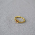 Close-up of gold braided brass ring featuring a round translucent pink stone inlay - US 6 / Purple Crystal